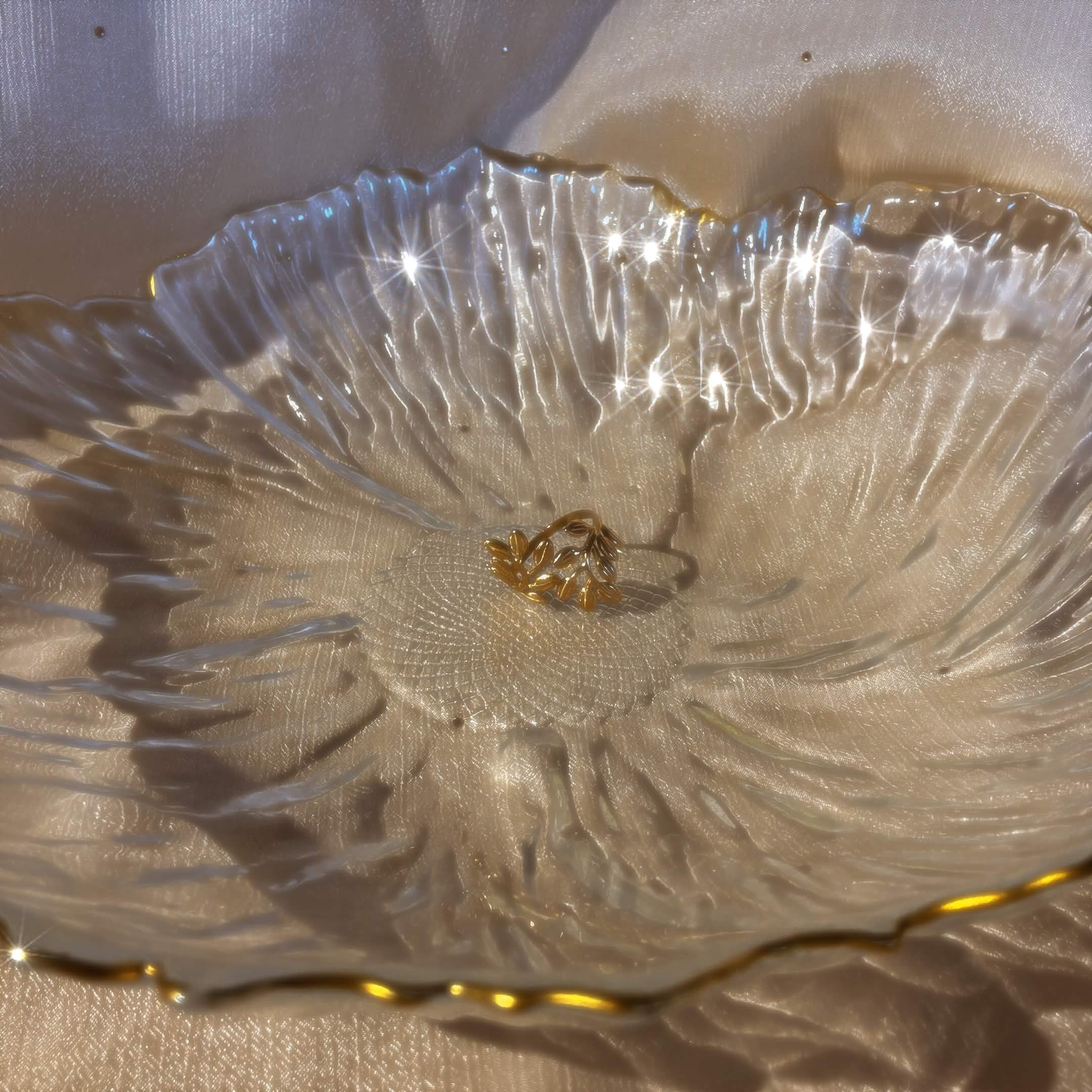 Gold laurel wreath charm in crystal bowl